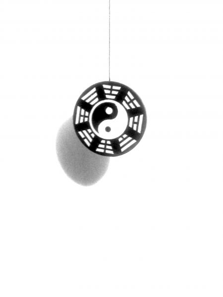 A középen függő ütőszárat  trigramokkal körülvett Yin - Yang jeles korong tartja feszesen.